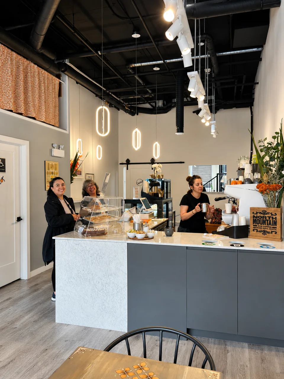 Inside a Pria Cafe and Deli, showing the counter and baristas