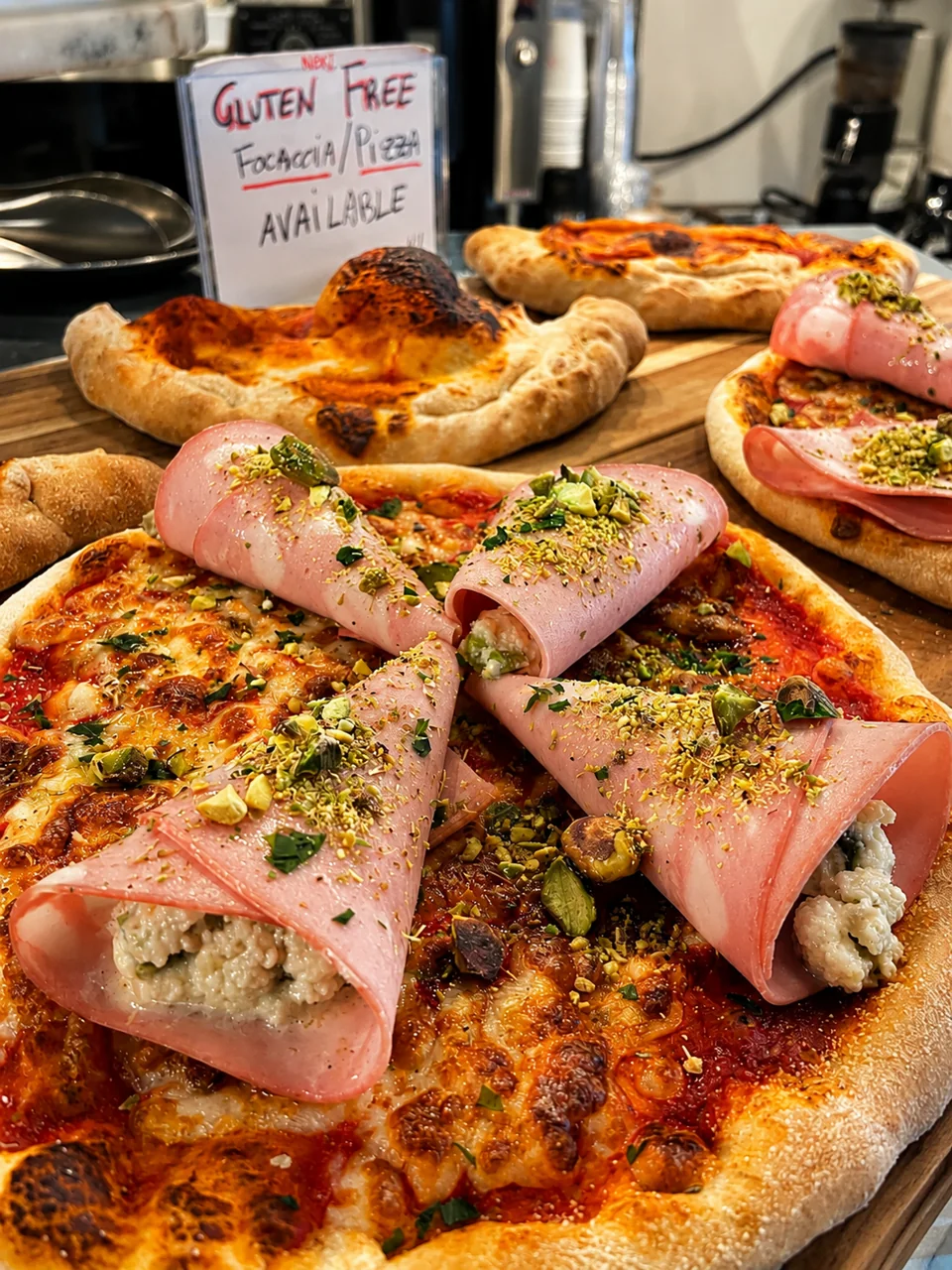 Pizza with rolled savoury bites on a board