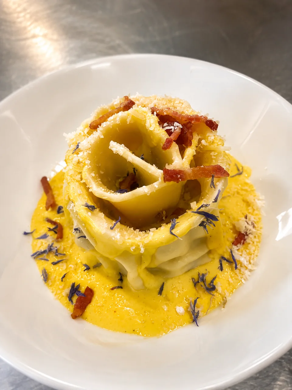 A plated pasta dish with bacon and cheese