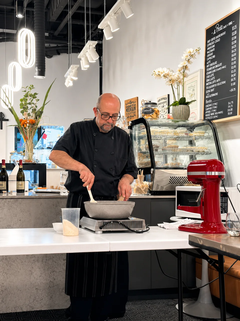 A chef preparing food behind the counter at a Pria